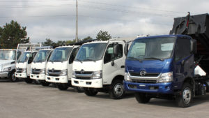 line up of hino trucks with a blue one to the far right