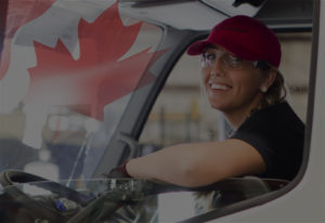 Woman smiling in truck cab with canadian flag